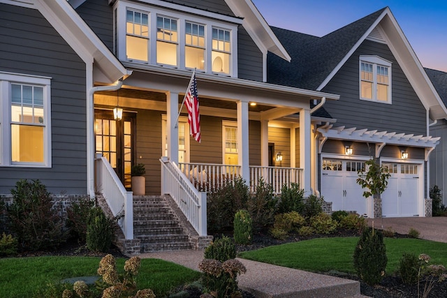 view of front of home with driveway, an attached garage, and a porch
