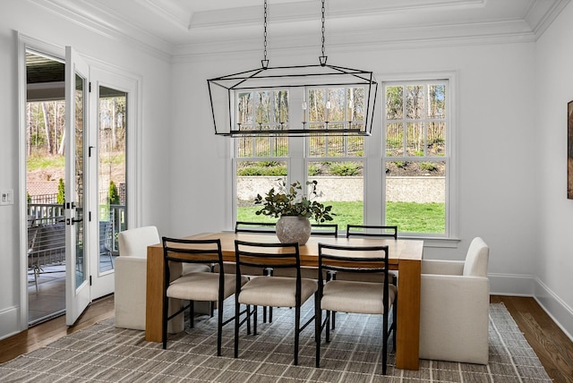 dining space featuring ornamental molding, baseboards, and wood finished floors