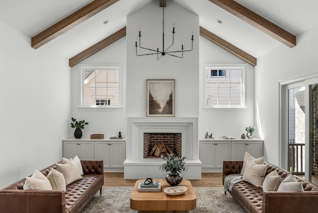living room with an inviting chandelier, vaulted ceiling with beams, and light wood finished floors
