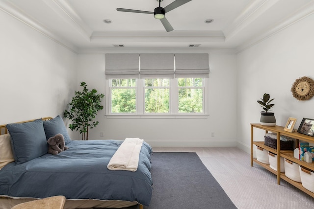 bedroom featuring a raised ceiling, light carpet, and visible vents