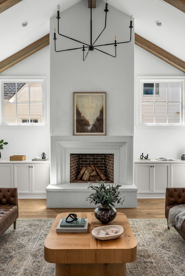 living area with vaulted ceiling with beams, a notable chandelier, light wood-style flooring, and recessed lighting