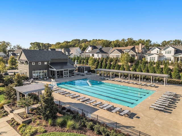 pool featuring a pergola, a residential view, a patio area, and fence