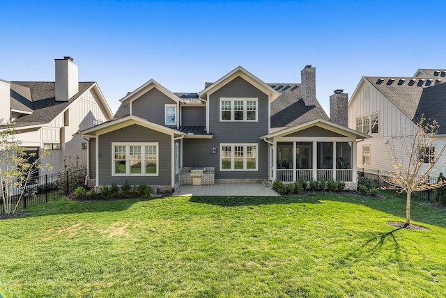 back of house featuring a sunroom, a fenced backyard, a yard, and a patio area