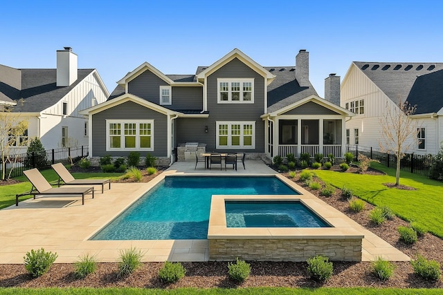 rear view of house with a sunroom, a fenced backyard, an in ground hot tub, a lawn, and a patio area