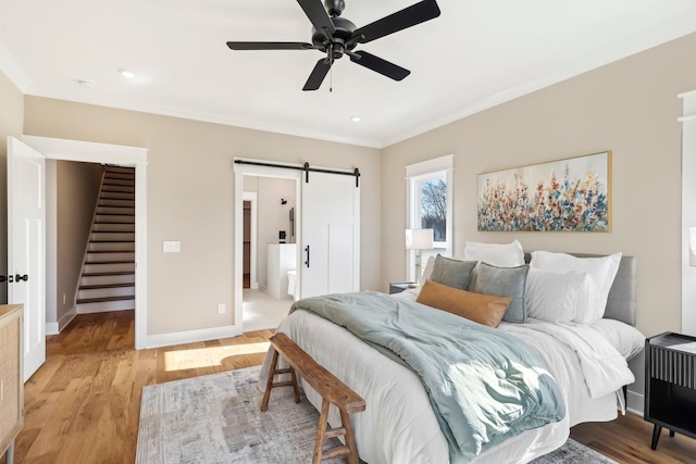 6477 Simmons Acres Ln, Lascassas, TN 37085 - bedroom featuring a barn door, light wood-style flooring, ceiling fan, and ensuite bathroom