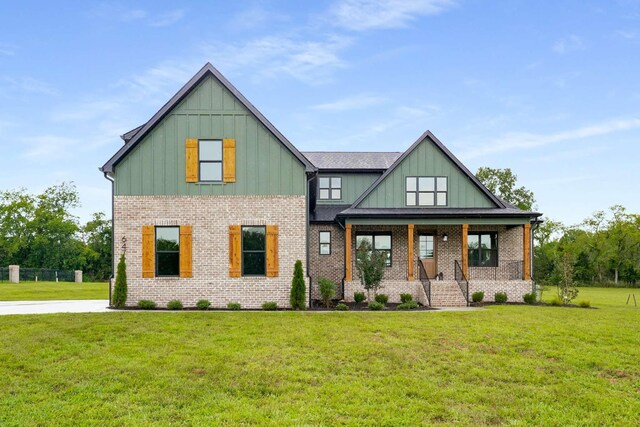 6477 Simmons Acres Ln, Lascassas, TN 37085 - view of front facade featuring board and batten siding, a porch, a front lawn, and brick siding