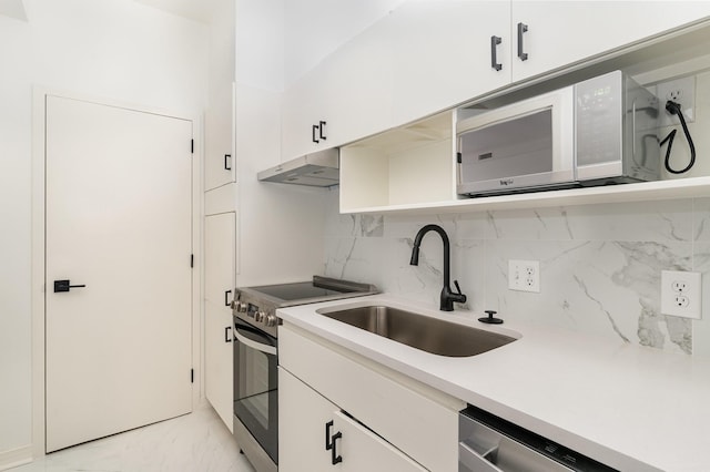 105 Leake Ave Unit 44, Nashville, TN 37205 - kitchen featuring light countertops, under cabinet range hood, marble finish floor, a sink, and appliances with stainless steel finishes