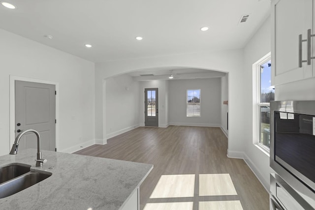 166 Oasis Dr, La Vergne, TN 37086 - kitchen featuring visible vents, light wood-style flooring, recessed lighting, arched walkways, and a sink