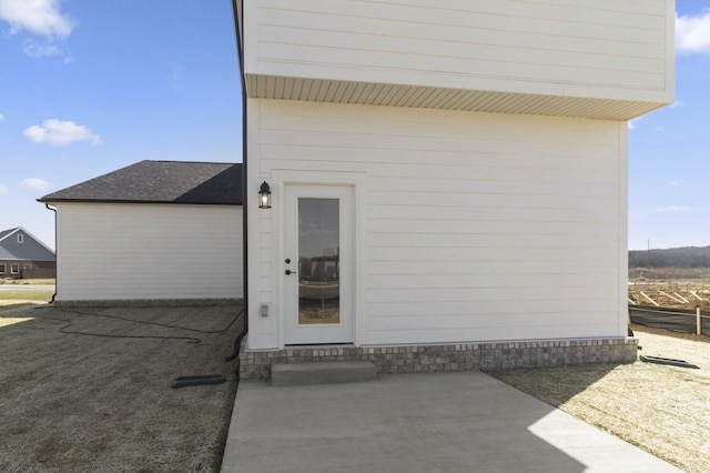 166 Oasis Dr, La Vergne, TN 37086 - view of exterior entry with roof with shingles and a patio