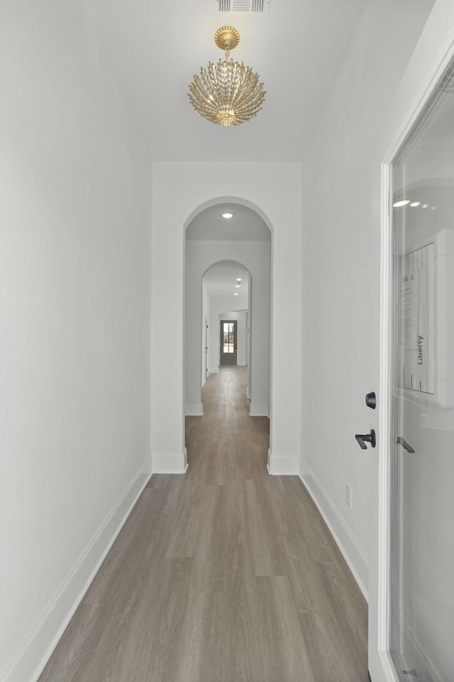 166 Oasis Dr, La Vergne, TN 37086 - hallway featuring visible vents, arched walkways, baseboards, and wood finished floors
