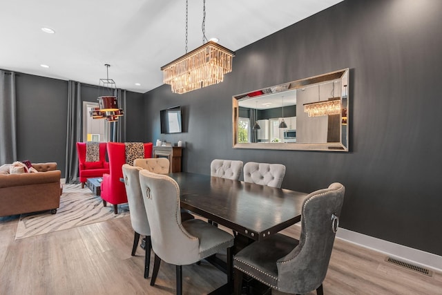 dining area featuring a chandelier, wood finished floors, baseboards, visible vents, and recessed lighting