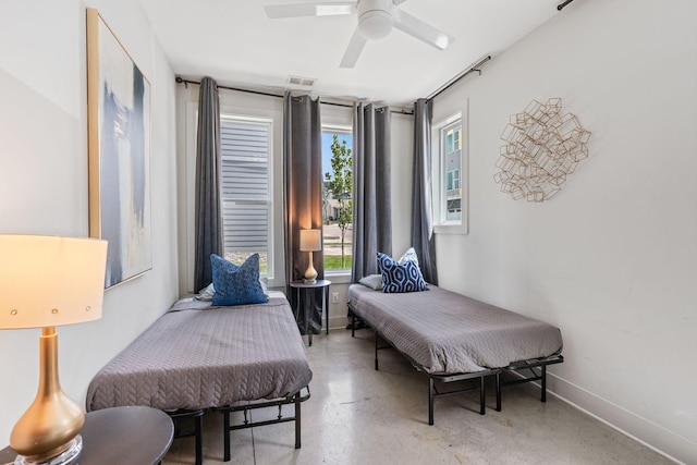 bedroom with baseboards, visible vents, ceiling fan, and concrete flooring