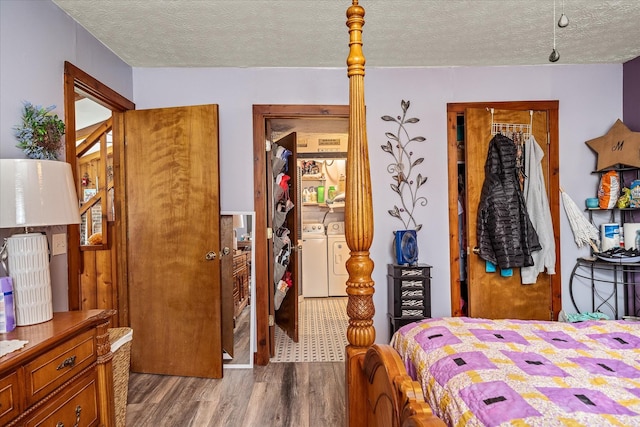 bedroom featuring washing machine and dryer, a textured ceiling, and wood finished floors