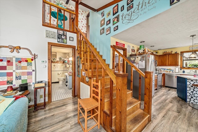 staircase featuring baseboards, visible vents, and wood finished floors