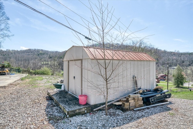 view of shed featuring a view of trees