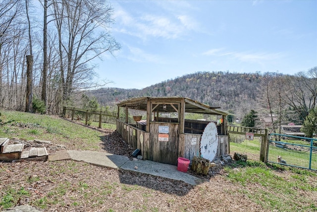 view of yard featuring an outbuilding, a forest view, and a mountain view