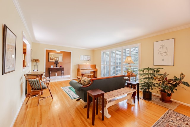living room featuring baseboards, light wood-type flooring, and ornamental molding