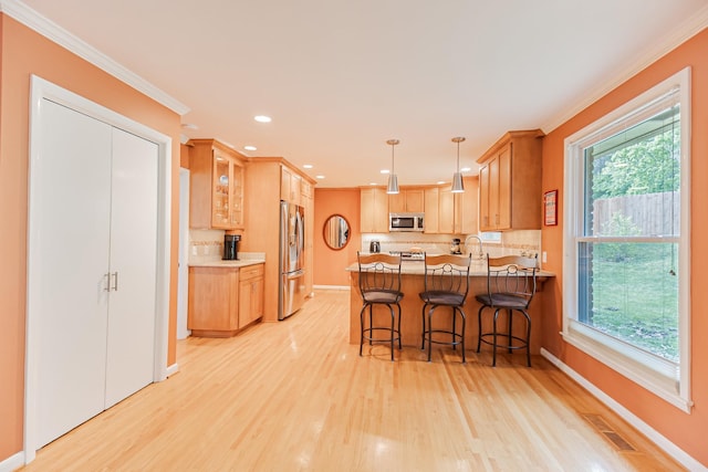 kitchen featuring ornamental molding, visible vents, stainless steel appliances, and a peninsula