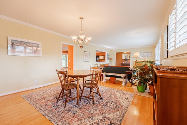dining room with baseboards, a notable chandelier, crown molding, and light wood-type flooring