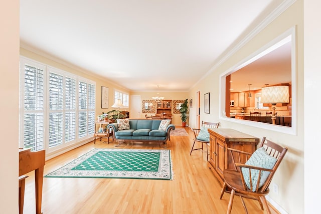living room featuring baseboards, ornamental molding, wood finished floors, and a chandelier