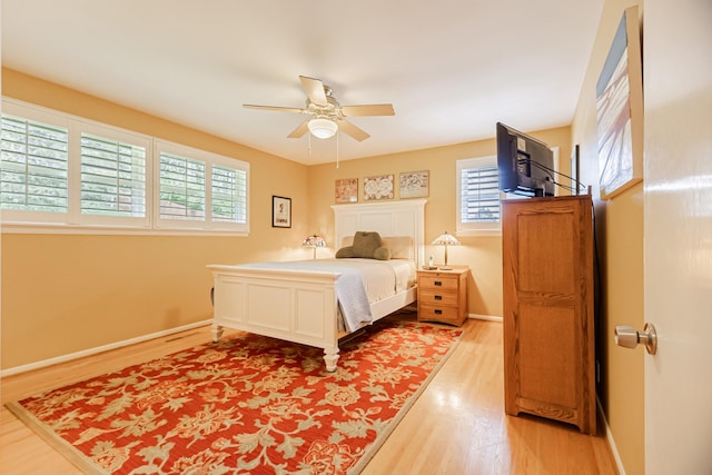 bedroom with baseboards, a ceiling fan, and light wood-type flooring