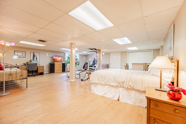 bedroom featuring visible vents, wood finished floors, and a paneled ceiling