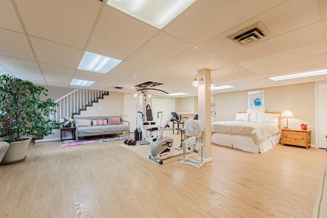 workout room featuring baseboards, visible vents, wood finished floors, and a drop ceiling
