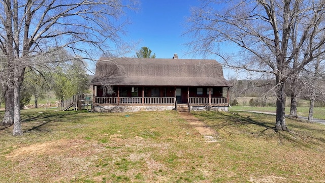 view of front of property with a gambrel roof, roof with shingles, a front yard, covered porch, and a chimney