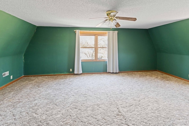 additional living space with carpet floors, baseboards, ceiling fan, and a textured ceiling