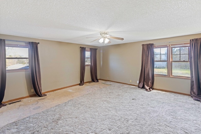 empty room featuring baseboards, a ceiling fan, and a healthy amount of sunlight