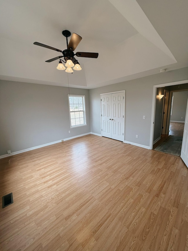 996 Iron Hill Rd, Burns, TN 37029 - unfurnished bedroom featuring baseboards, visible vents, light wood-style floors, and a raised ceiling