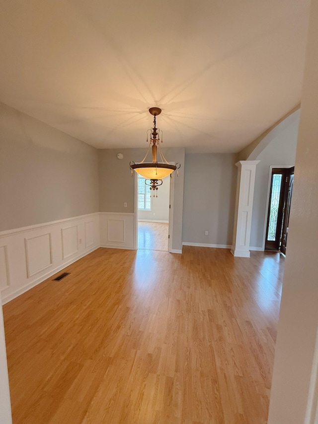 996 Iron Hill Rd, Burns, TN 37029 - spare room with a wainscoted wall, a decorative wall, visible vents, arched walkways, and light wood-type flooring