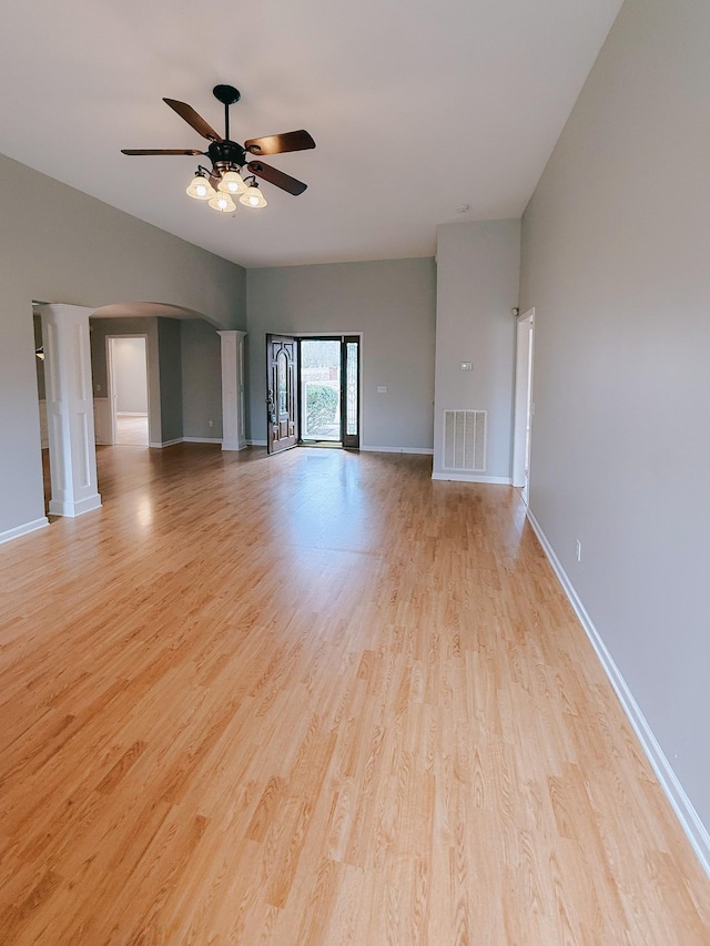 996 Iron Hill Rd, Burns, TN 37029 - unfurnished living room with a ceiling fan, light wood-style flooring, baseboards, visible vents, and arched walkways