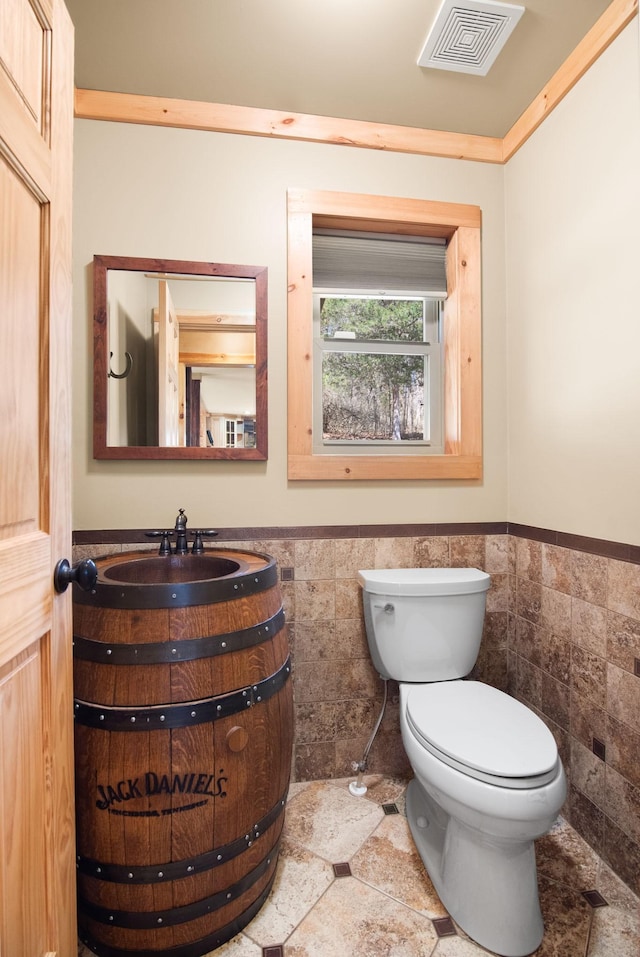 12112 Paw Paw Springs Rd, Arrington, TN 37014 - half bath featuring a wainscoted wall, visible vents, toilet, and tile walls