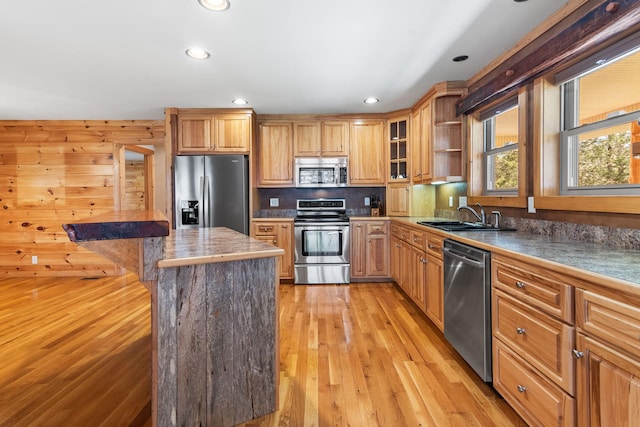 12112 Paw Paw Springs Rd, Arrington, TN 37014 - kitchen featuring stainless steel appliances, glass insert cabinets, a sink, light wood-type flooring, and a breakfast bar area