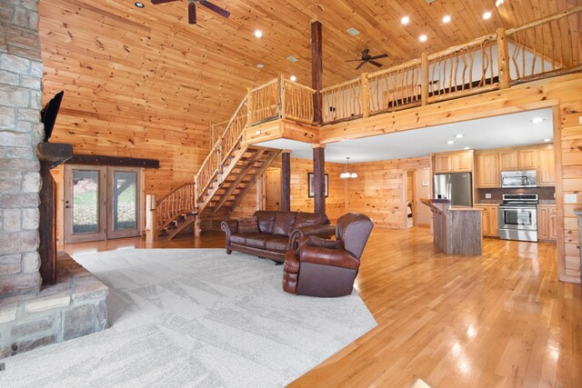 12112 Paw Paw Springs Rd, Arrington, TN 37014 - living room with light wood-style flooring, wood walls, stairs, a ceiling fan, and wood ceiling