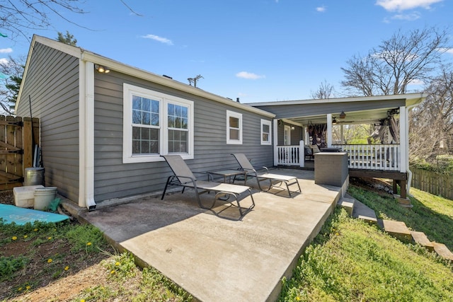 rear view of property with fence, covered porch, and a patio area