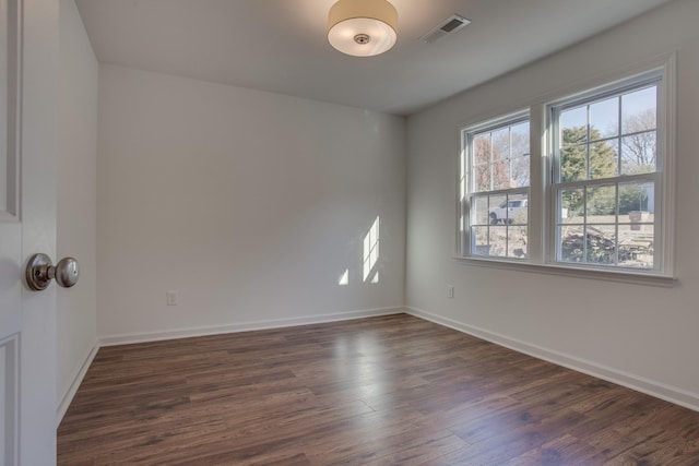 empty room featuring dark wood-style flooring and baseboards