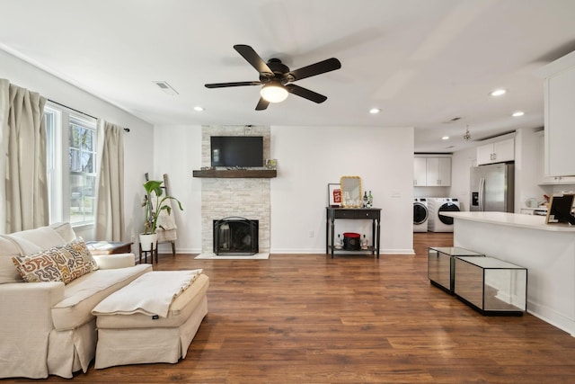 living area with separate washer and dryer, recessed lighting, ceiling fan, a fireplace, and dark wood finished floors