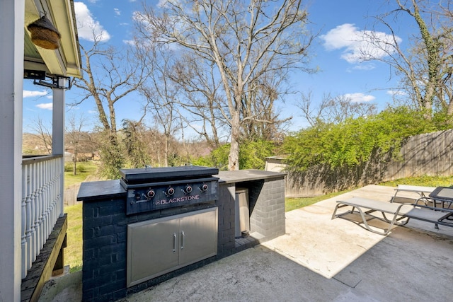 view of patio / terrace with an outdoor kitchen, a grill, and fence