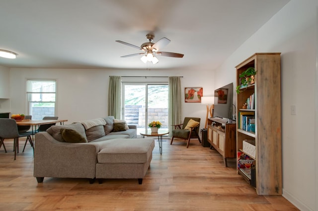 living room featuring a wealth of natural light, ceiling fan, and light wood finished floors