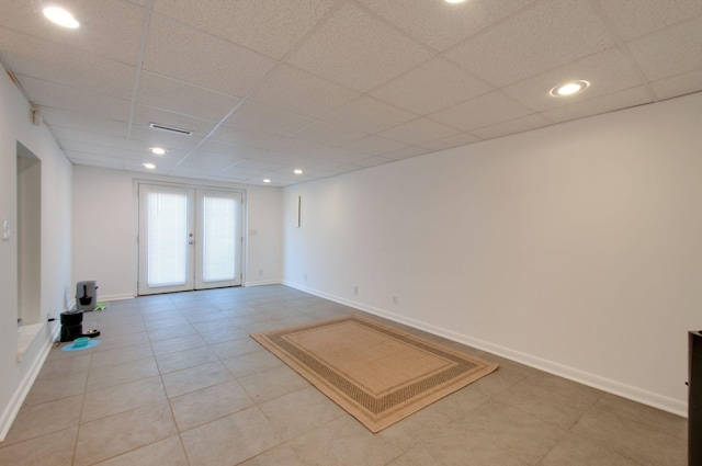empty room featuring recessed lighting, french doors, baseboards, a drop ceiling, and visible vents