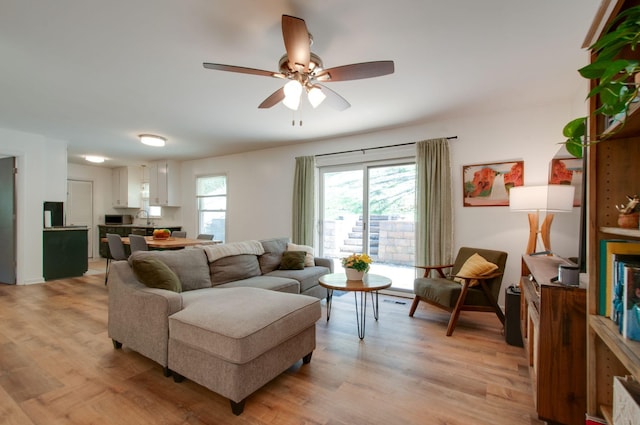 living room featuring light wood-style flooring and a ceiling fan