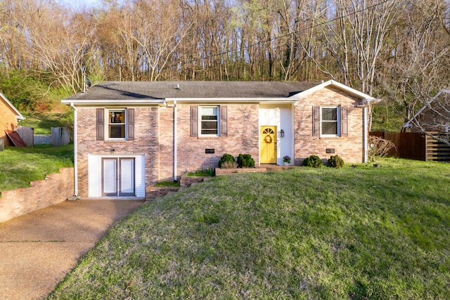 view of front facade featuring brick siding, fence, and a front lawn