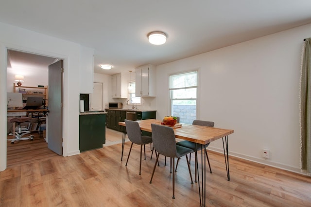 dining space with baseboards and light wood-style floors