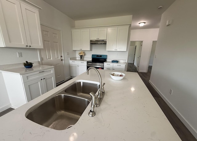 7022 Magnolia Ln, Nunnelly, TN 37137 - kitchen with stainless steel range with electric cooktop, a sink, under cabinet range hood, white cabinets, and baseboards
