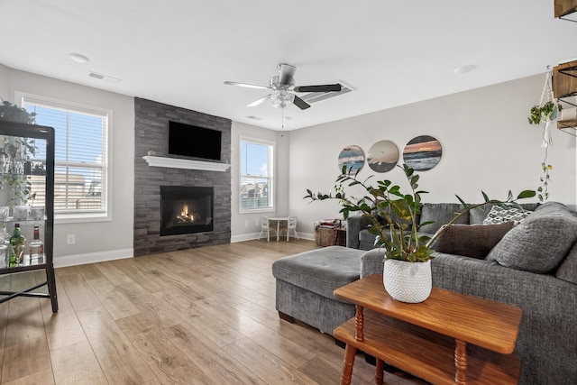 living area with light wood finished floors, visible vents, a ceiling fan, and a healthy amount of sunlight