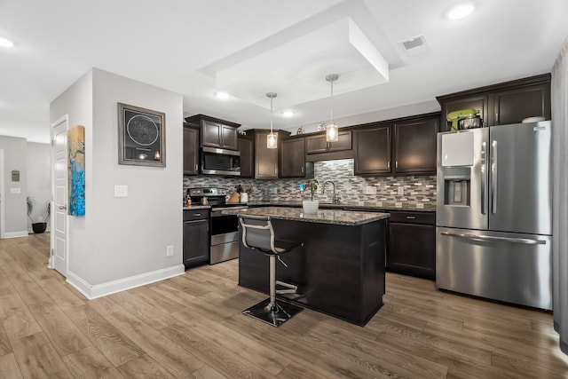 kitchen with a sink, visible vents, stainless steel appliances, and light wood finished floors