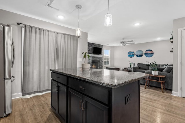 kitchen featuring visible vents, light wood-style flooring, a ceiling fan, and freestanding refrigerator
