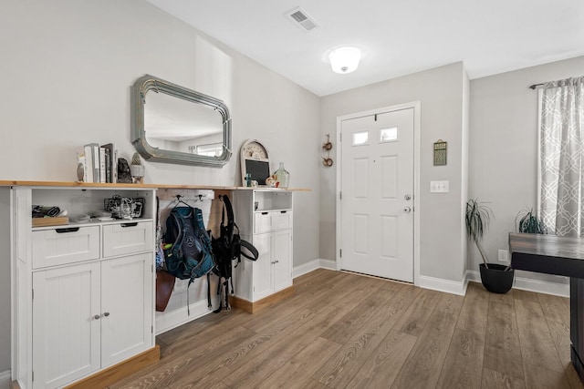 entryway with baseboards, visible vents, and light wood-style flooring